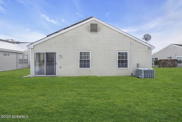 rear view of house with a yard and central AC