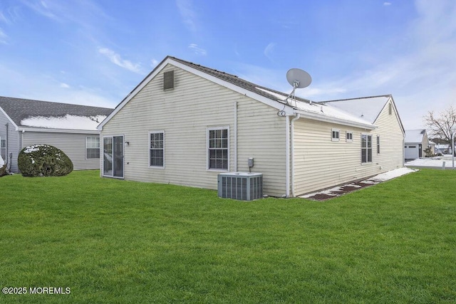 back of house featuring central AC unit and a lawn