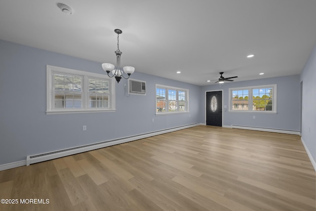 unfurnished living room featuring plenty of natural light, a baseboard heating unit, and a wall unit AC