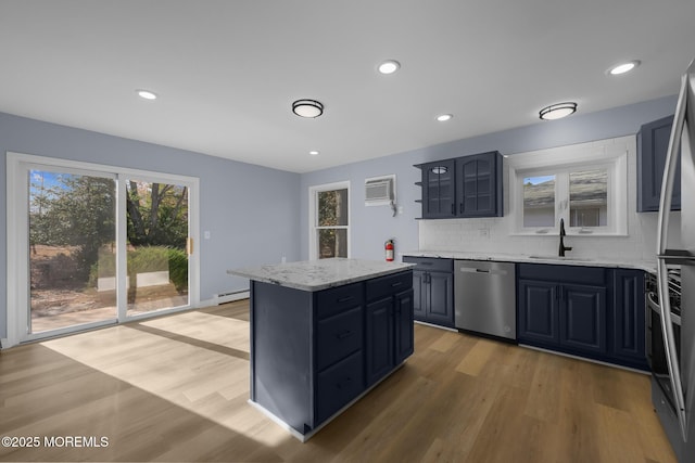 kitchen with dishwasher, a kitchen island, a baseboard heating unit, light hardwood / wood-style floors, and sink