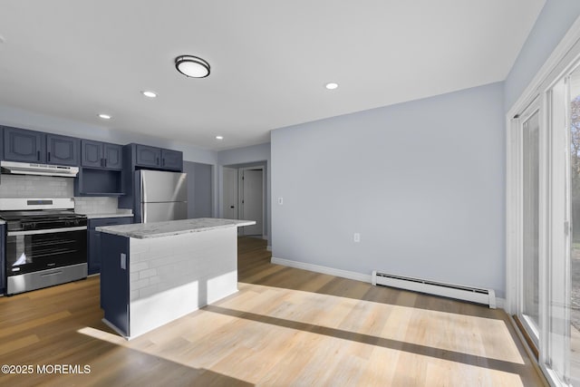 kitchen featuring baseboard heating, stainless steel gas range, decorative backsplash, light hardwood / wood-style floors, and refrigerator