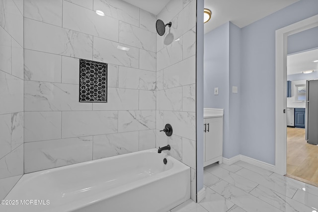 bathroom with tiled shower / bath combo and vanity