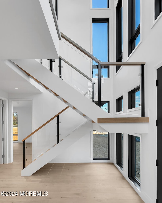 stairs featuring hardwood / wood-style flooring and a towering ceiling