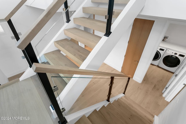 stairs featuring washing machine and clothes dryer and hardwood / wood-style flooring