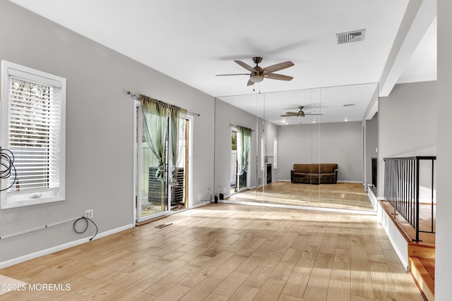 unfurnished living room with ceiling fan, light hardwood / wood-style floors, and a wealth of natural light