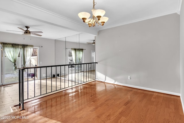 empty room with ornamental molding, hardwood / wood-style floors, and ceiling fan with notable chandelier