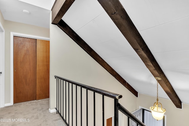 hallway featuring beamed ceiling and carpet flooring