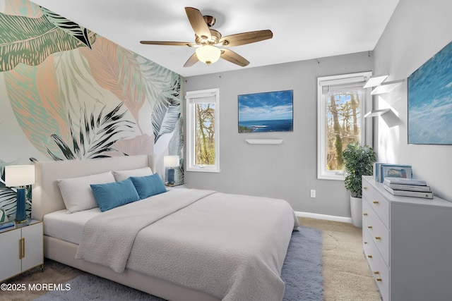 bedroom featuring ceiling fan, multiple windows, and light carpet