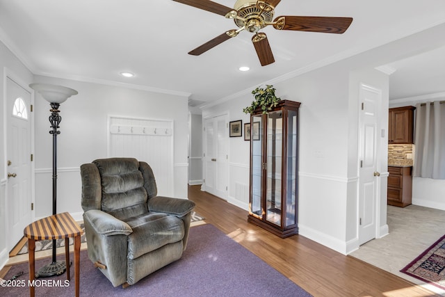 sitting room featuring crown molding and light hardwood / wood-style floors