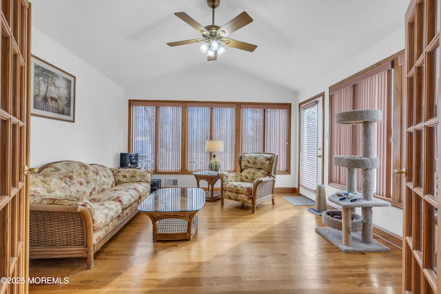 living room featuring ceiling fan, light hardwood / wood-style flooring, and lofted ceiling