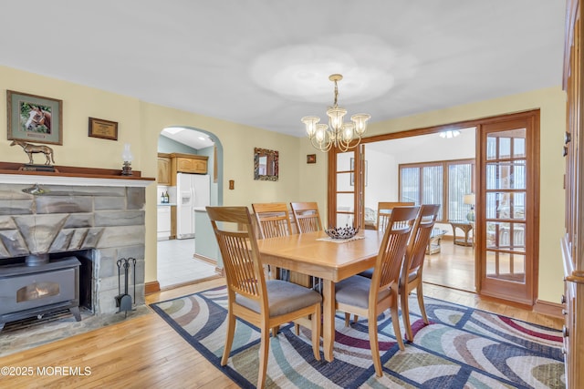 dining area with light hardwood / wood-style flooring, lofted ceiling, and an inviting chandelier