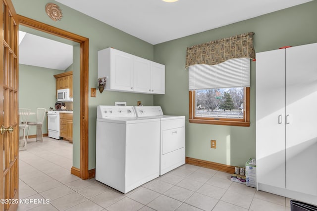 laundry area with light tile patterned floors, cabinets, and independent washer and dryer