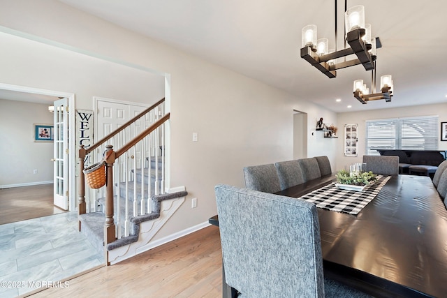 dining space with a notable chandelier and hardwood / wood-style flooring