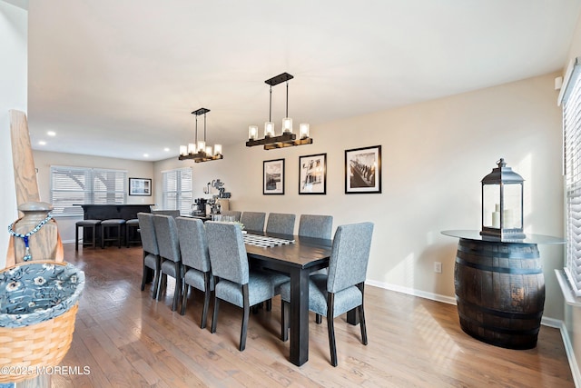 dining space featuring hardwood / wood-style flooring and an inviting chandelier