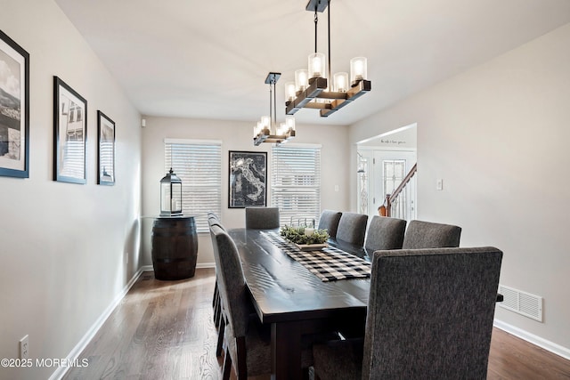 dining room with a notable chandelier and dark hardwood / wood-style flooring