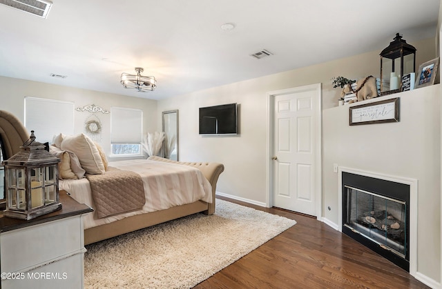 bedroom featuring a notable chandelier and dark hardwood / wood-style flooring