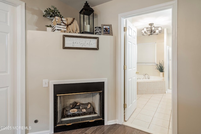 interior details with a fireplace, hardwood / wood-style flooring, and a notable chandelier