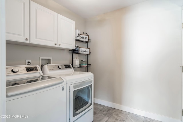 clothes washing area featuring light tile patterned floors, cabinets, and washer and dryer