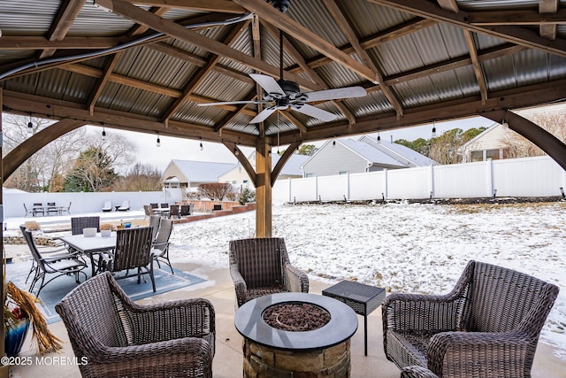 snow covered patio featuring an outdoor fire pit, a gazebo, and ceiling fan