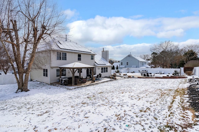 snow covered back of property featuring a gazebo