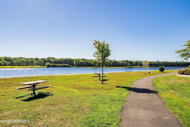 surrounding community featuring a lawn and a water view