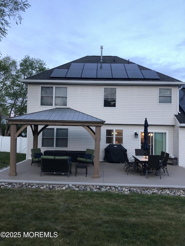 rear view of house with a patio area, a gazebo, and solar panels