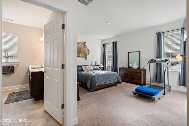 bedroom featuring light colored carpet and multiple windows