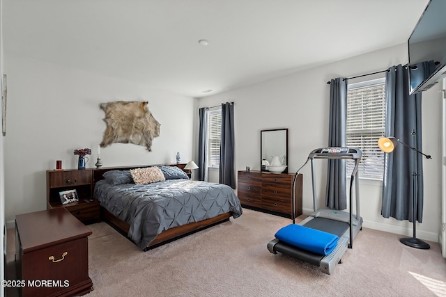 bedroom with light colored carpet and multiple windows