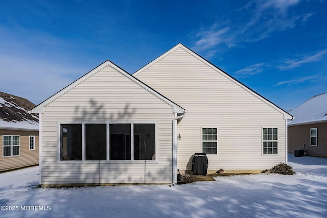 snow covered property with central AC unit