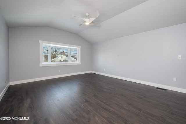 empty room with ceiling fan, dark hardwood / wood-style floors, and lofted ceiling