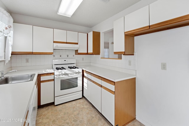 kitchen with sink, white appliances, white cabinets, and backsplash