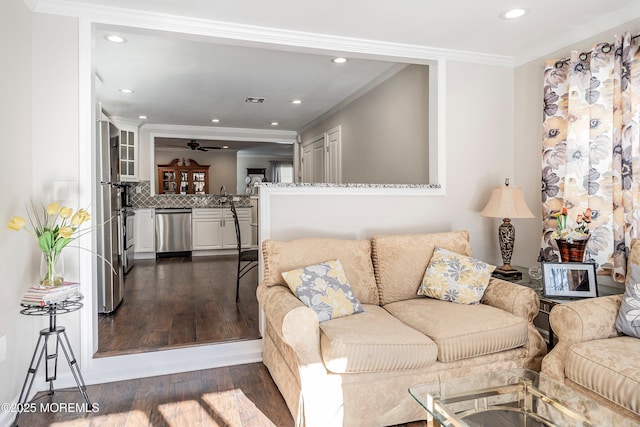 living room featuring ornamental molding, dark wood-type flooring, sink, and ceiling fan