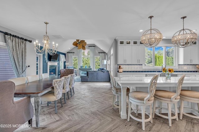 dining area featuring light parquet floors, lofted ceiling, and an inviting chandelier