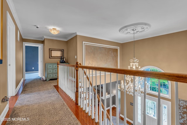 hall with wood-type flooring, a notable chandelier, and ornamental molding