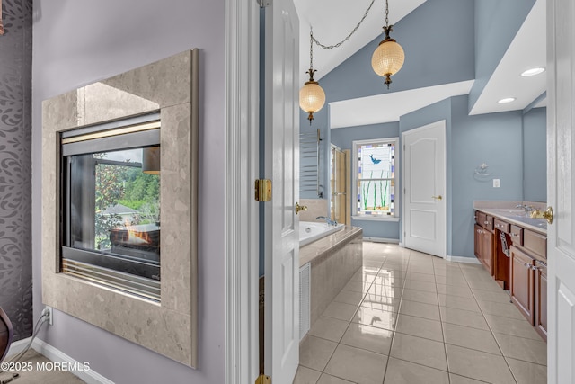 bathroom with vanity, tiled tub, tile patterned flooring, and lofted ceiling