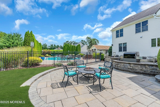 view of patio / terrace featuring an outdoor fire pit, a fenced in pool, an outdoor kitchen, and grilling area