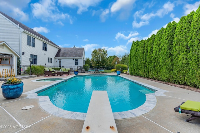 view of swimming pool with an in ground hot tub, a patio area, a bar, and a diving board