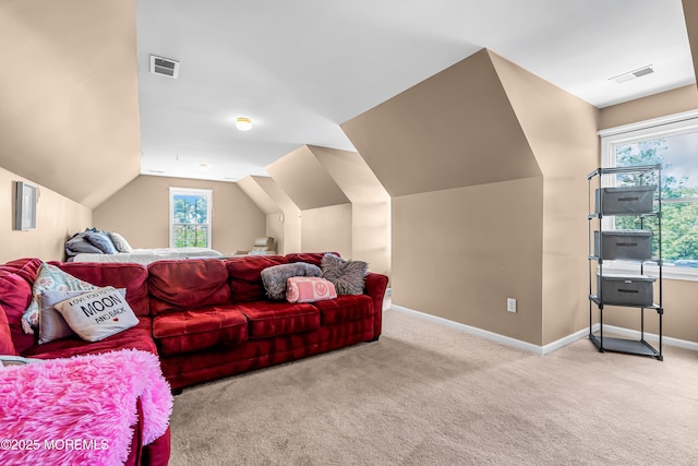 carpeted living room with plenty of natural light and lofted ceiling