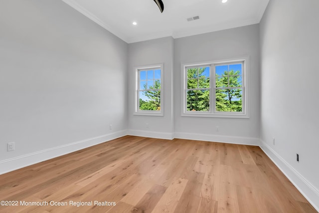 empty room featuring ornamental molding and light wood-type flooring