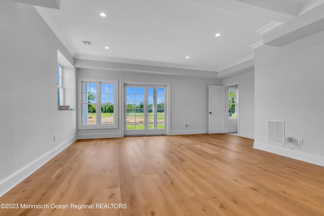 empty room with crown molding and light hardwood / wood-style floors