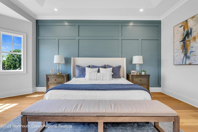 bedroom featuring crown molding and light wood-type flooring