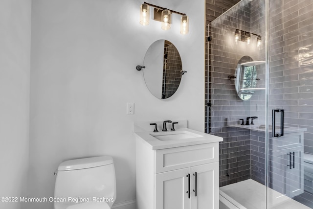 bathroom featuring a shower with door, vanity, and toilet