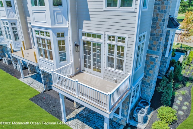 rear view of property featuring a yard and central AC unit