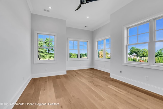 spare room featuring crown molding, ceiling fan, and light wood-type flooring