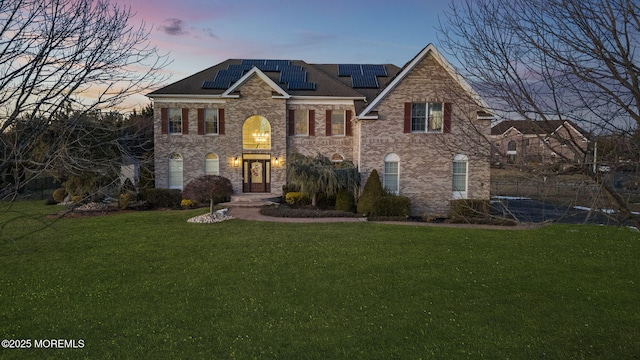 view of front of house with a yard and solar panels