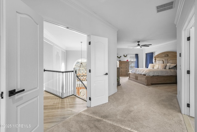 bedroom featuring crown molding, ceiling fan with notable chandelier, and light colored carpet