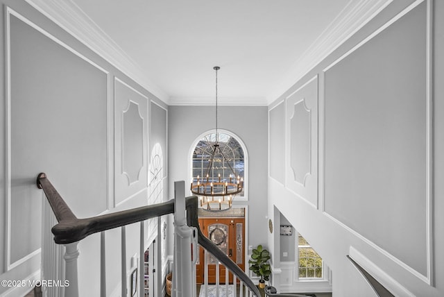 hall featuring ornamental molding and an inviting chandelier