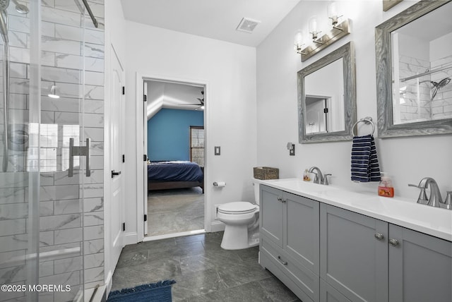 bathroom with a shower with door, vanity, and toilet