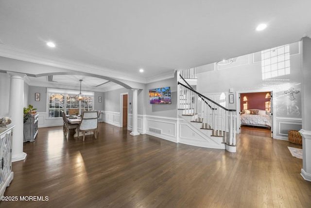 interior space featuring decorative columns, ornamental molding, and dark hardwood / wood-style floors