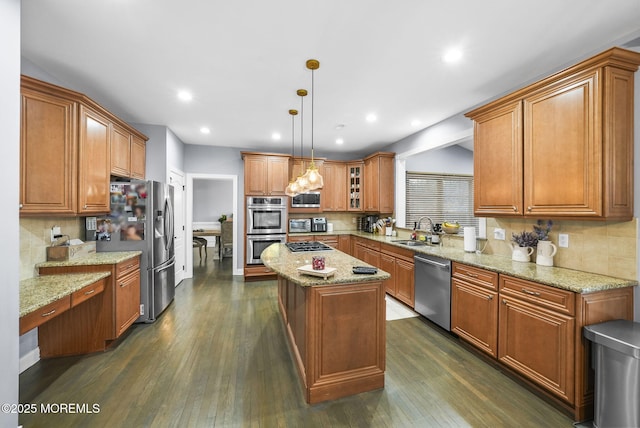 kitchen with sink, hanging light fixtures, dark hardwood / wood-style flooring, a kitchen island, and stainless steel appliances